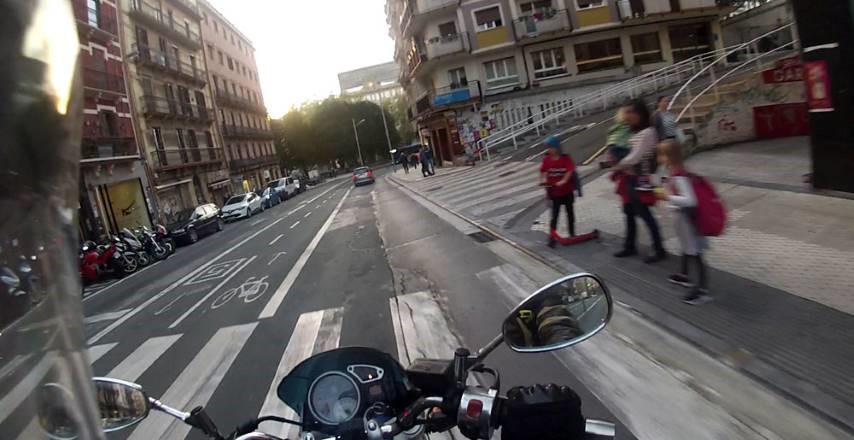 Una moto circula por una calle rodeada de potenciales riesgos