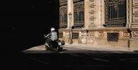Una moto circula por una calle con poca luz