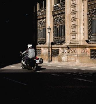 Una moto circula por una calle con poca luz