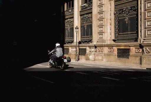 Una moto circula por una calle con poca luz
