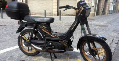 Ciclomotor con pedales aparcado en la calle