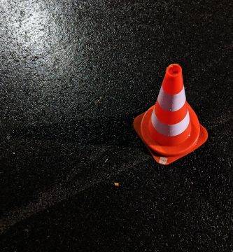Un cono de obra sobre asfalto mojado