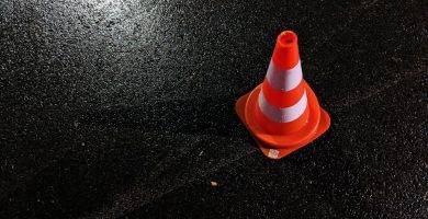 Un cono de obra sobre asfalto mojado