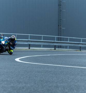 Un motorista toca con la rodilla al tomar una curva de una carretera abierta al tráfico