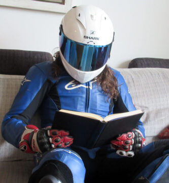 Motorista equipado leyendo un libro en un sofá