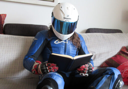 Motorista equipado leyendo un libro en un sofá