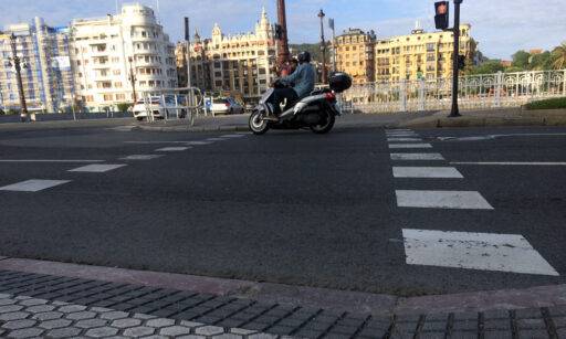 Una moto cruza por un paso de peatones taqueado