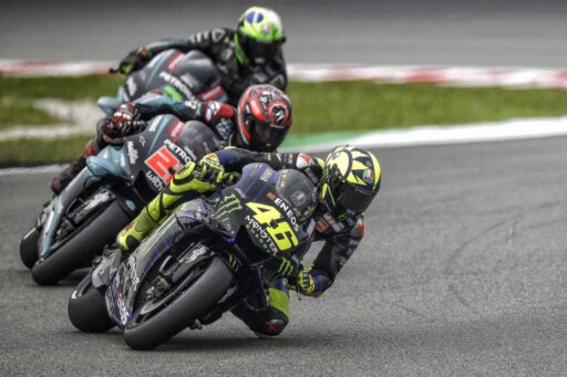 Valentino Rossi seguido de los dos pilotos del Petronas Yamaha SRT durante una carrera de MotoGP