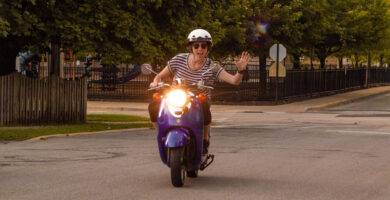 Una motorista sin guantes saluda a la cámara