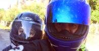 Padre e hijo miran a cámara subidos en una moto