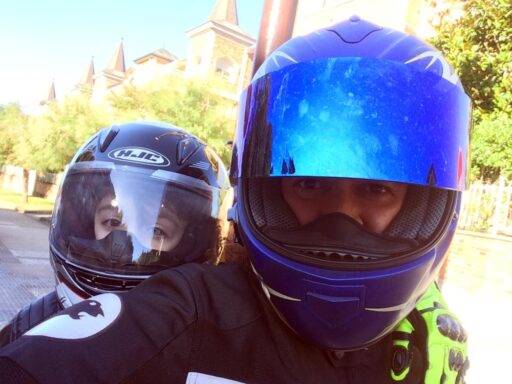 Padre e hijo miran a cámara subidos en una moto