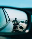 Motocicleta reflejada en el retrovisor de un coche