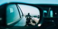 Motocicleta reflejada en el retrovisor de un coche