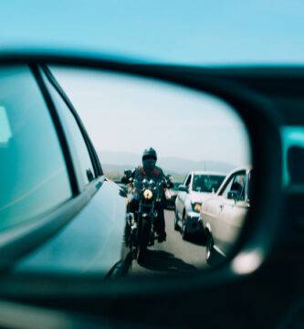 Motocicleta reflejada en el retrovisor de un coche