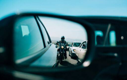 Motocicleta reflejada en el retrovisor de un coche